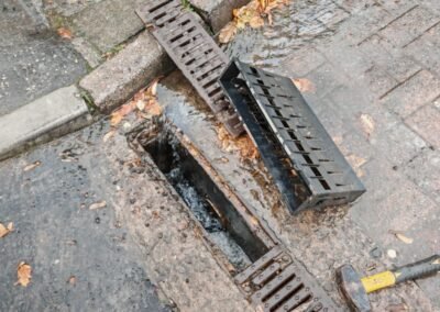 Drainage channel opened for cleaning with covers removed at a commercial site