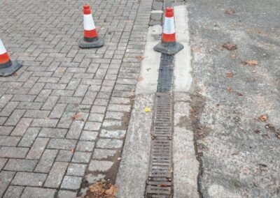 Surface drainage channel along the entrance to a fuel station before cleaning